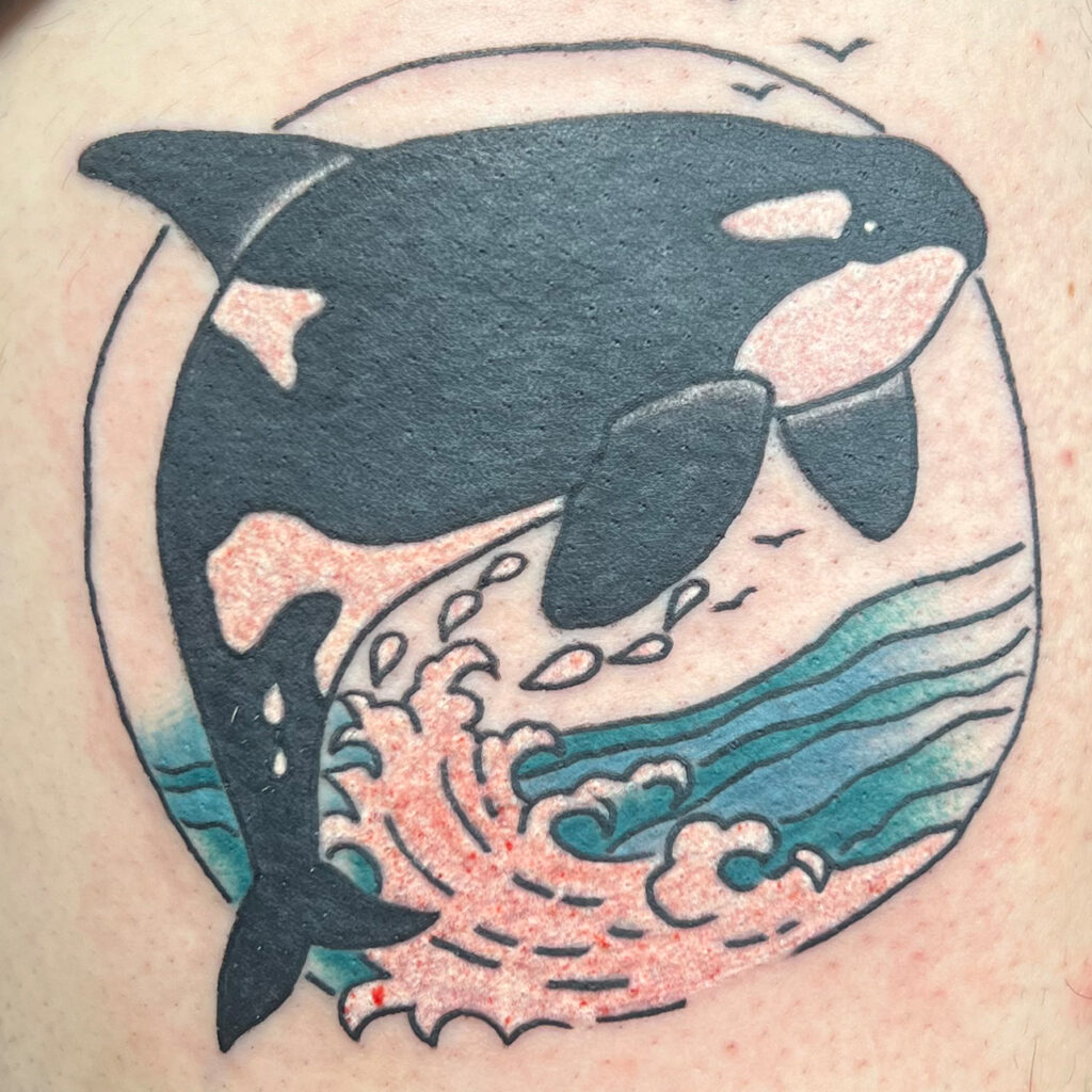 Full color cartoon character with block lettering on a thigh