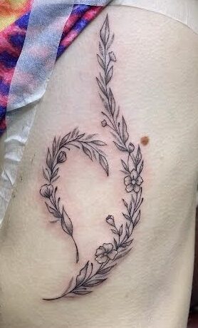 Black and grey flowers, leaves and a butterfly running down a forearm